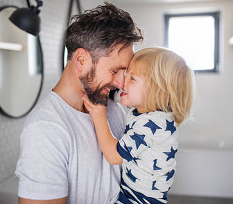 Man holding son and smiling