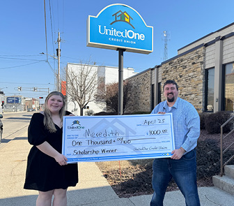 Image of two people holding a scholarship check Chief Marketing Officer Mike Farley presents a scholarship donation check to Meredith Putman of Manitowoc